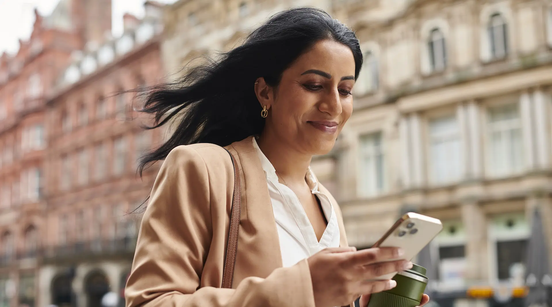 Woman Holding A Phone Walking To Work